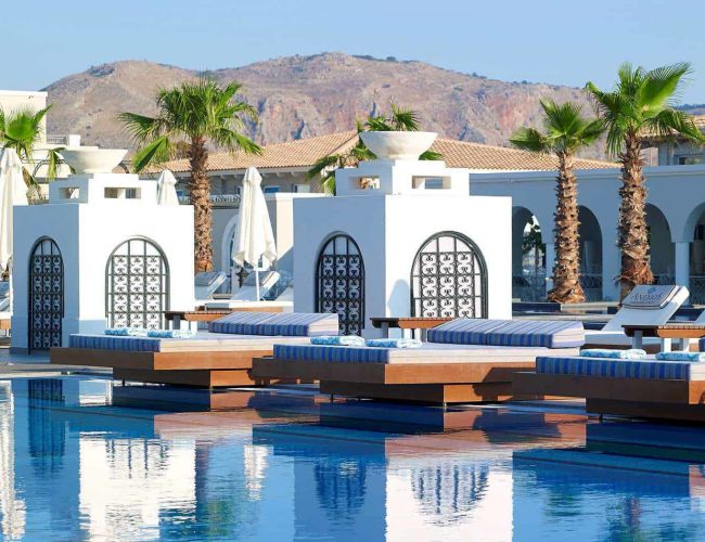 A Pool With Lounge Chairs And Palm Trees